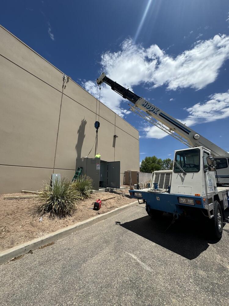 Crane setting electrical equipment at a commercial building in Tucson, Arizona